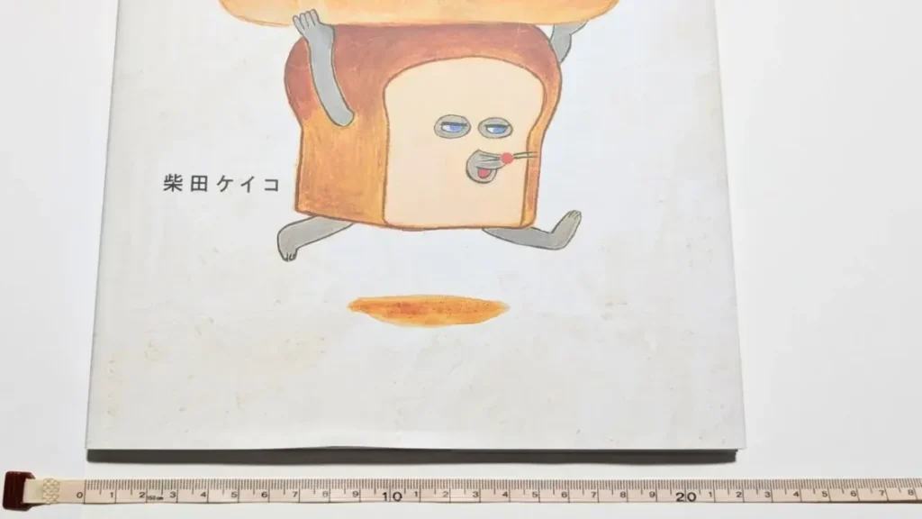 メジャーを使って絵本『パンどろぼう』の横幅を測っている様子