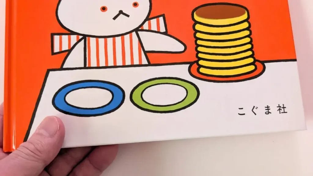 手に持った絵本『しろくまちゃんのほっとけーき』の表紙のアップ