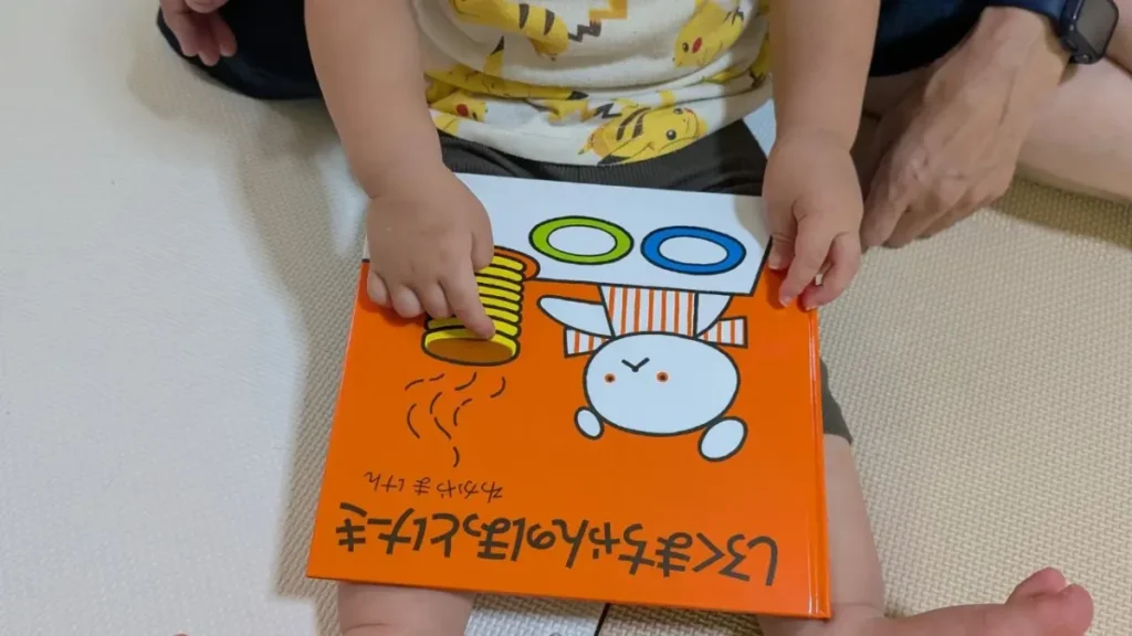 子どもが『しろくまちゃんのほっとけーき』の表紙を指で触っている様子