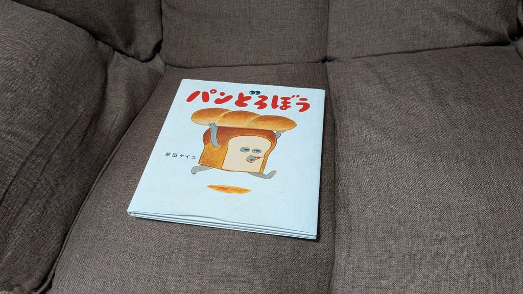茶色のソファの座面に置かれた絵本「パンどろぼう」